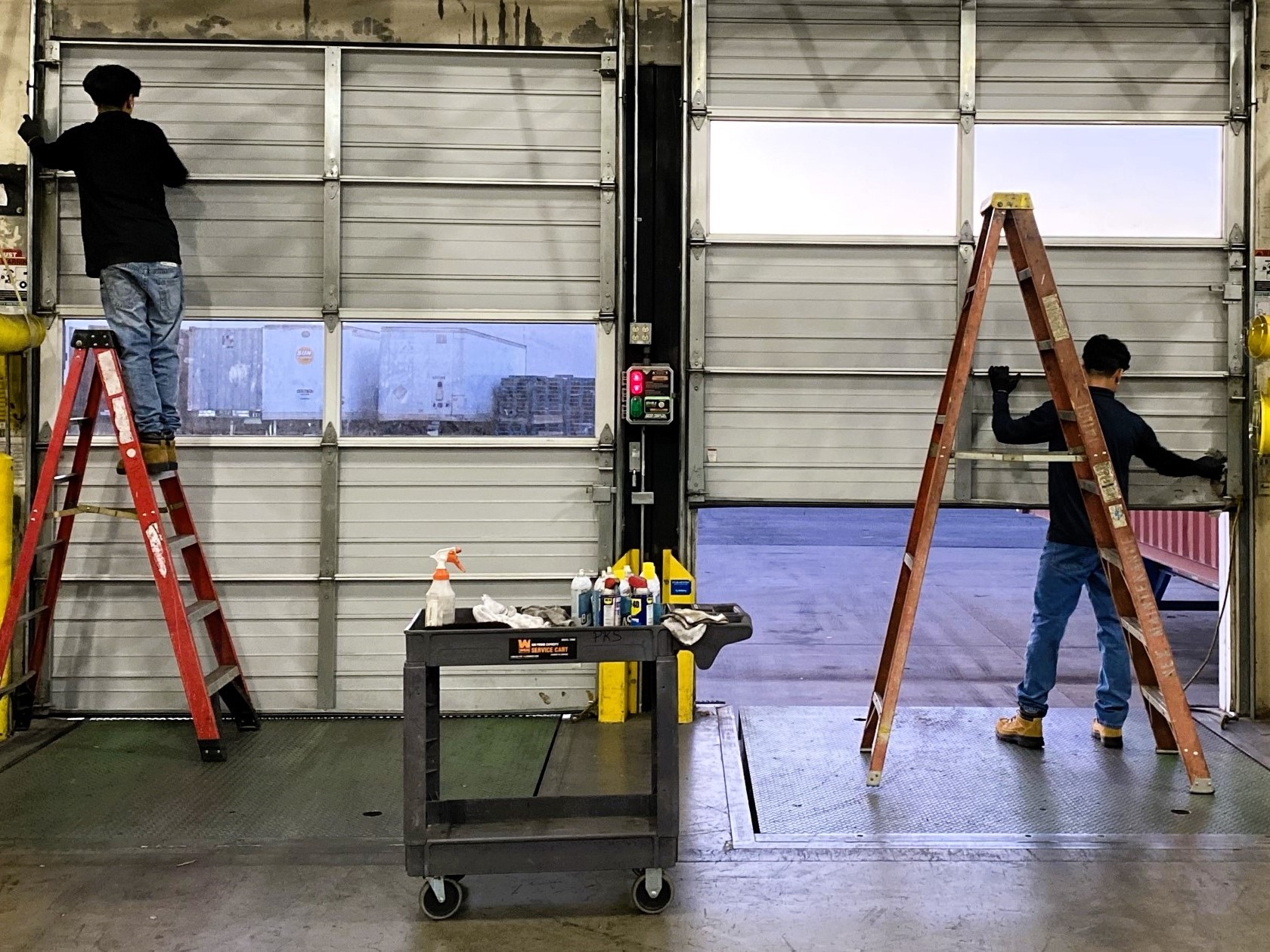 Technicians performing facilities maintenance on dock doors